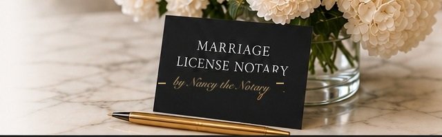 A black Marriage License Notary place card and a gold pen beside white hydrangeas on a marble surface